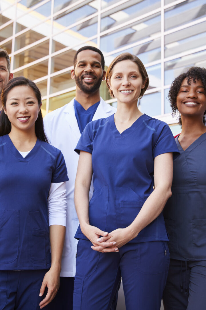 Smiling medical team standing together outside a hospital